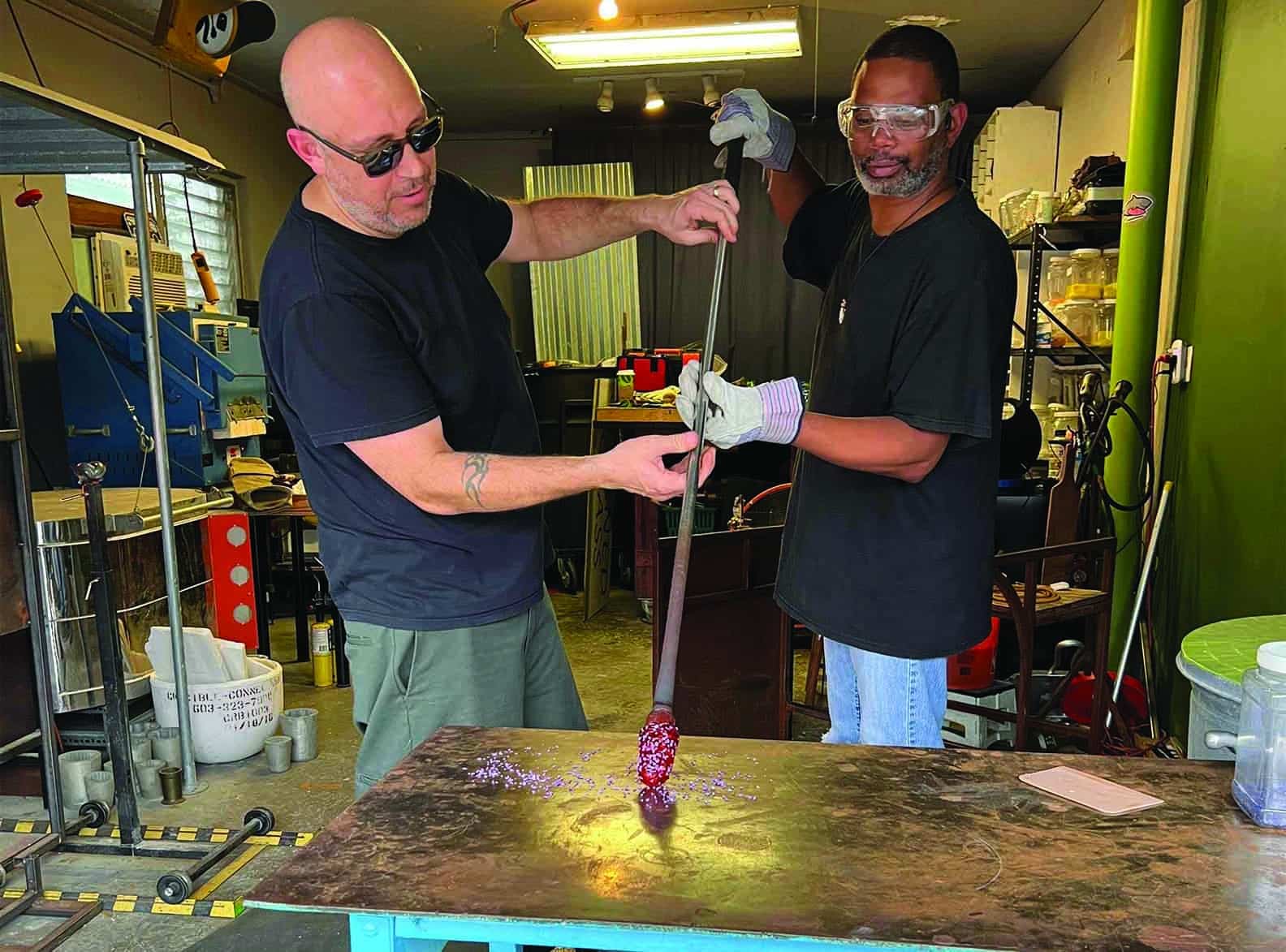 two men blowing glass.
