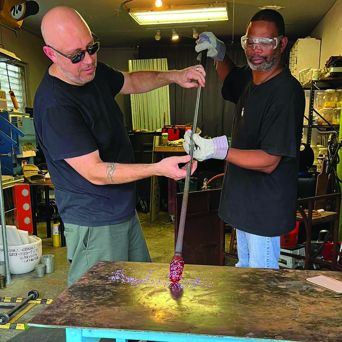 two men blowing glass.